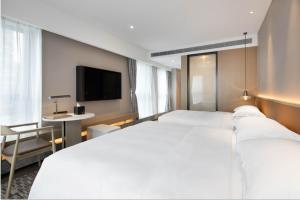 Postel nebo postele na pokoji v ubytování Leeden Hotel Hangzhou
