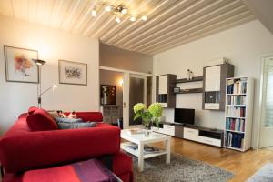 sala de estar con sofá rojo y mesa en Ferienwohnung Anita en Villach