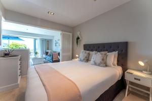 a bedroom with a large bed with a large window at Oneroa Bay Villas in Oneroa