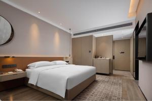Postel nebo postele na pokoji v ubytování Leeden Hotel Hangzhou