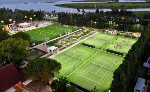 een uitzicht op een tennisbaan met twee tennisbanen bij Isamar Holiday Village in Ca Lino