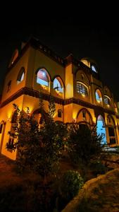un grand bâtiment avec des lumières allumées la nuit dans l'établissement Tasneem Palace, à Louxor