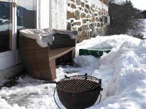 un cubo de basura en la nieve al lado de un edificio en 5 person holiday home in Lomen, en Løken