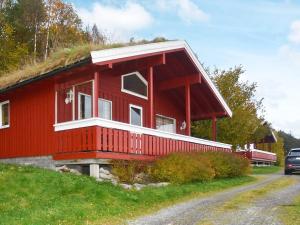 a red house with a grass roof on a hill at 6 person holiday home in VATNE in Vatne