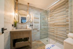 ein Badezimmer mit Dusche, Waschbecken und Spiegel in der Unterkunft Bed and Snow Family Apartments in Sierra Nevada + 60 Fotos