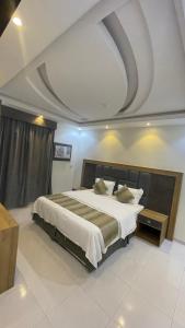 ein Schlafzimmer mit einem großen Bett mit Kassettendecke in der Unterkunft شقق الشاطئ in Al Qunfudhah