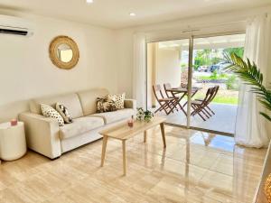 sala de estar con sofá y mesa en Maracuja 6, Orient Bay village, walkable beach at 100m, en Orient Bay