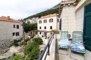 un par de sillas en un balcón con edificios en Holiday Home Patricija, en Dubrovnik