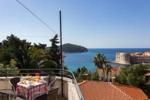 a table on a balcony with a view of the ocean at Holiday Home Patricija in Dubrovnik