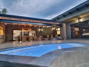 - une piscine en face d'une maison dans l'établissement Kruger Nights, à Marloth Park