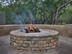 a fire pit in a yard with flames at Kruger Nights in Marloth Park