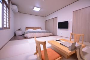 a bedroom with a bed and a desk and a table at Daigo - Vacation STAY 07998v in Kanayama
