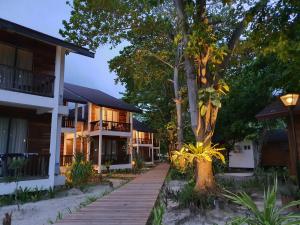 a house on the beach with a wooden walkway at Borneo Divers Mabul Resort in Pulau Mabul 