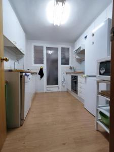 タマリウにあるApto Residencial en Tamariuの白いキャビネット付きの広いキッチン +8枚の写真