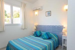 um quarto com uma cama e duas janelas em Résidence Canava em Bonifacio