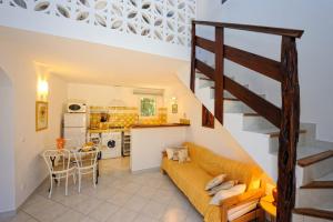 a living room with a couch and a kitchen at Résidence Canava in Bonifacio