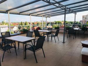 a patio with tables and chairs on a roof at Hotel Nostalgia in Senec