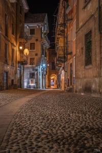 an empty street in an old town at night at NicoMat Rooms in Domodossola