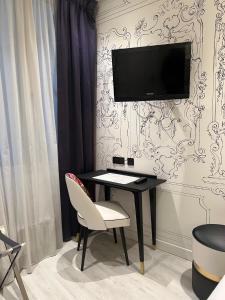 a room with a desk and a tv on a wall at Hotel Massena in Paris +20 photos