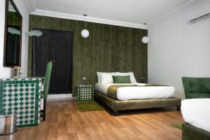 a bedroom with a bed and a green wall at Hotel Majestic in Casablanca