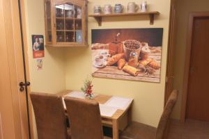 a dining room table with a painting on the wall at Ferienwohnung Messerschmidt in Quedlinburg +4 photos