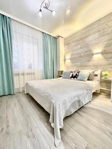 sypialnia z dużym łóżkiem z niebieskimi zasłonami w obiekcie Tiffany Apartment w mieście Irpień