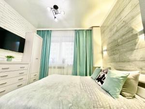 sypialnia z dużym łóżkiem i drewnianą ścianą w obiekcie Tiffany Apartment w mieście Irpień