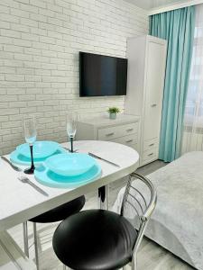 Pokój ze stołem z 2 krzesłami i telewizorem w obiekcie Tiffany Apartment w mieście Irpień