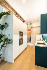 una cucina con armadi bianchi e una pianta in vaso di Beautiful appartment in the heart of Antwerp ad Anversa