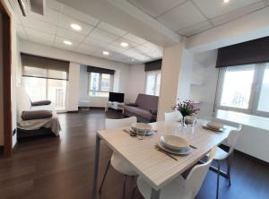 ein Esszimmer mit einem Tisch und weißen Stühlen in der Unterkunft Apartamentos Castillo Peñiscola 3000 in Peñíscola