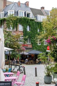 un hotel con sedie e tavoli rosa e un edificio di Beautiful appartment in the heart of Antwerp ad Anversa Altre 28 foto