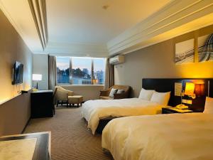 Cette chambre comprend 2 lits et une fenêtre. dans l'établissement Felicity Business Hotel, à Taichung