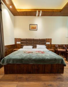 ShamshiMathan View Homestay - 3min Drive to Kullu-Manali Airport的卧室里有一张大床，上面铺着绿色毯子