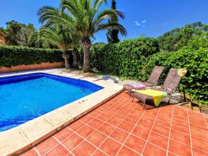 una piscina con dos sillas y una palmera en Villas Monte Verde -BTB, en Jávea
