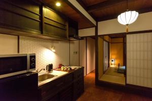 una cocina con fregadero y microondas en KyoMachiya Stars, en Kioto