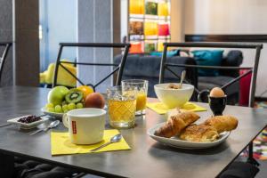a table with breakfast foods and drinks on it at Hôtel Le Mistral in Marseille