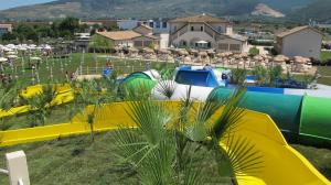 a group of tents in a field with houses at Hotel & Resort Le Colombare in Foligno