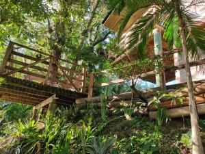 a wooden bridge in the middle of a garden at Bangalô do Rio - Timbé do Sul in Timbe do Sul
