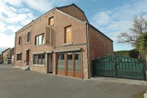 a brick building with a gate in front of it at Le Moulin de Nancy in Hour