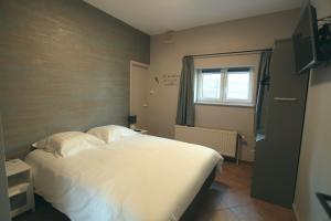 Schlafzimmer mit einem Bett mit weißer Bettwäsche und einem Fenster in der Unterkunft Le Moulin de Nancy in Hour