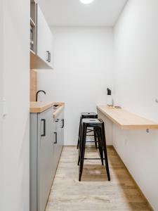 une cuisine avec un comptoir et un tabouret. dans l'établissement limehome Bamberg Keßlerstraße, à Bamberg