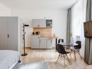 a small white kitchen with a table and chairs at limehome Bamberg Keßlerstraße in Bamberg