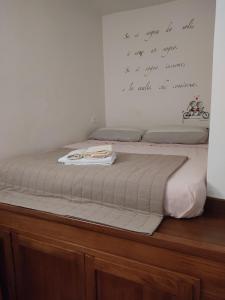 a bed in a room with a writing on the wall at Appartamento Terni Centro in Terni