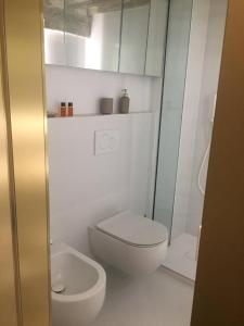 een witte badkamer met een toilet en een wastafel bij Pispini Apartment in Siena