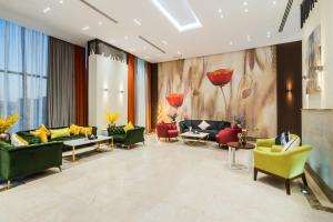 a lobby with couches and chairs in a room at Tulip Plaza Hotel in Sakakah