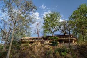 a resort building in the middle of trees at The Riverwood Forest Retreat Pench in Khawāsa