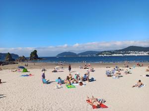 a group of people sitting on a beach at Indiano 4B in Viveiro