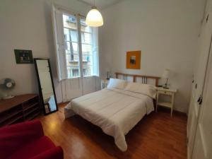 a bedroom with a large white bed and a mirror at Esparteria 1 in Barcelona