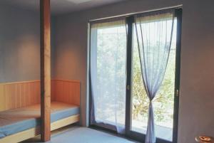 a bedroom with a large glass window with a bed next to it at -1日1組限定-犬と泊まれる古民家宿 wanco minca わんこみんか in Minamiawaji