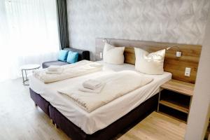 ein Schlafzimmer mit einem großen Bett mit weißen Laken und Kissen in der Unterkunft Haus am See Luxury HS 223 B in Hahnenklee-Bockswiese